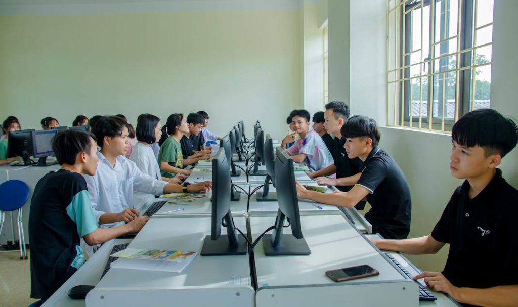young-boys-sitting-in-front-of-the-computers-in-the-class-5530442 Diverse group of students studying in a computer-equipped classroom setting.